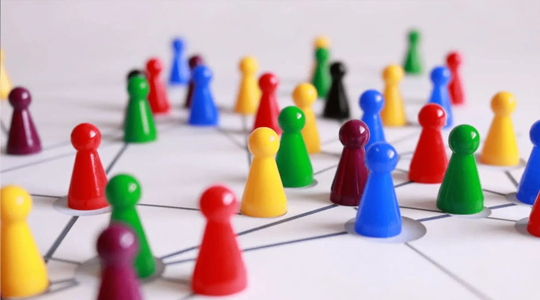
        
          a collection of multicoloured plastic figures spreadout on a piece of paper and connected to each other by straight lines
        
      
